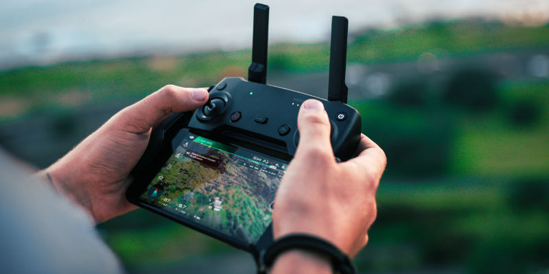 A close up of a person's hands holding a drone remote control.