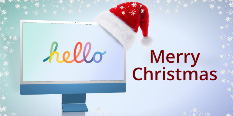 An iMac wearing a Christmas hat with snow falling around the words Merry Christmas.