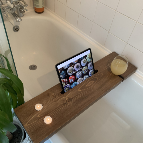 An iPhone in the oak phone stand.