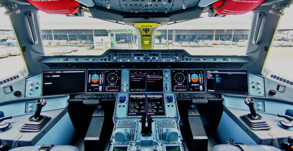 The cockpit of a plane sat at an airport terminal 